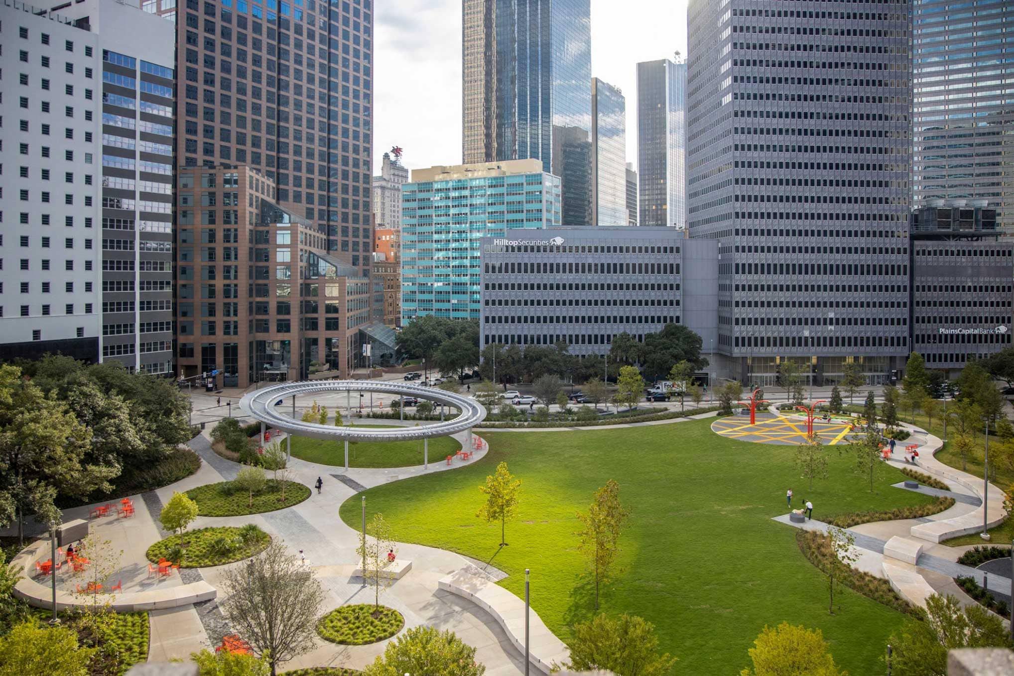 Dallas' Pacific Park Plaza is an oasis situated in a dense urban downtown neighborhood. With a playground, pavilion, and plenty of greenery, it offers a variety of choices for engaging with the natural world in the heart of the city.